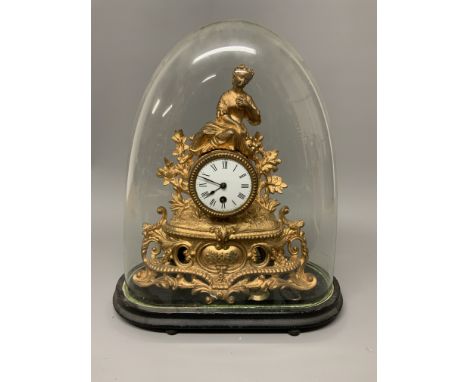 A french gilt mantle clock in glass dome on oval wooden base. W:36cm x D:16cm x H:43cm