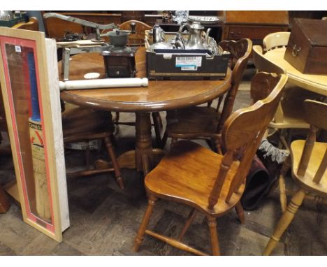 Circular oak single pillar dining table and four matching stick back chairs 