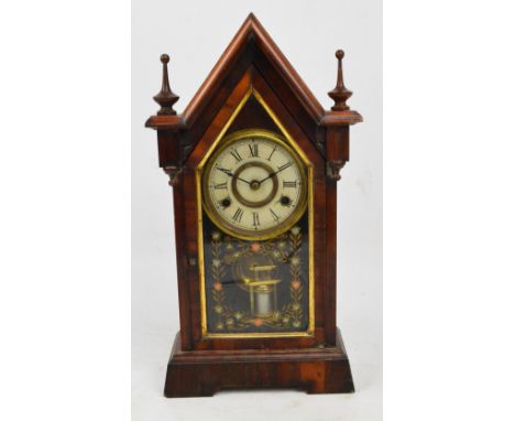 An American eight day mantel clock, the circular dial set with Roman numerals, with steeple pediment and turned finials, with