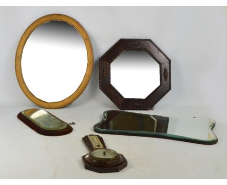 A collection of wall mirrors comprising an octagonal wooden framed example, an oval example, a shaped example, and a small ov