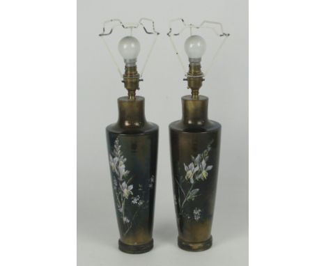A pair of ceramic lamp bases of tapering form decorated with sprays of orchids and flowers on a lustre ground, height excludi
