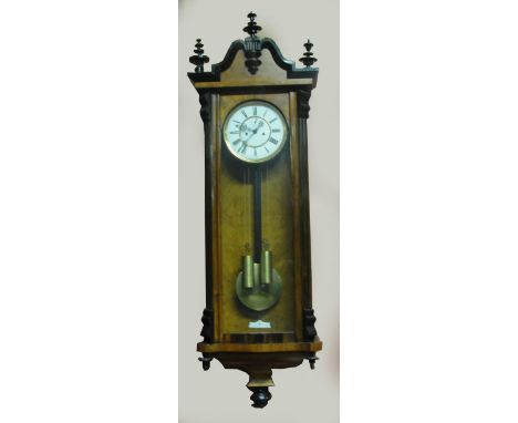 A late 19th century walnut and ebonised Vienna style twin weight wall clock with shaped pediment above white enamel dial hous