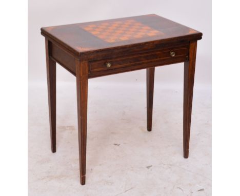 An Edwardian simulated rosewood foldover games table with chequerboard inlay to the hinged lid, baize playing surface and twi