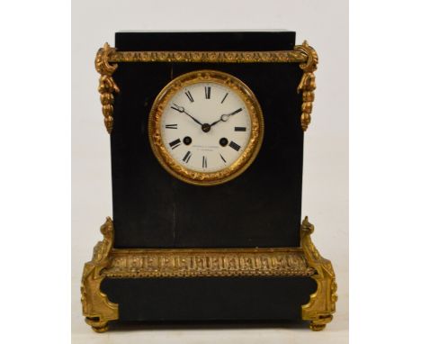A late 19th century ebonised and gilt metal mounted eight day mantel clock with circular white enamel dial set with Roman num