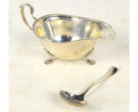 An Edward VIII hallmarked silver sauce boat with acanthus leaf decorated loop handle and with three outswept scallop decorate