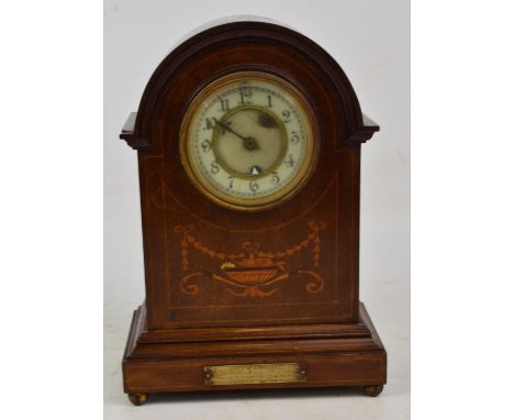 An early 20th century mahogany and inlaid dome top mantel clock, the circular dial set with Arabic numerals and bearing prese