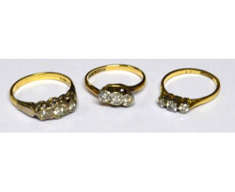 An 18ct yellow gold and platinum three stone diamond ring with pierced shoulders, size K and an 18ct yellow gold three stone 