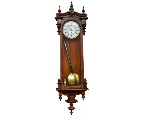 A late 19th century walnut Vienna single weight wall clock with white enamel dial, glazed door, and turned finials, length 12