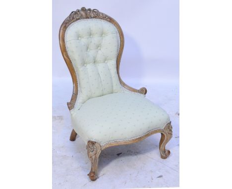 A late Victorian faded walnut ladies spoon back chair with button upholstered padded back, serpentine seat and knee carved ca