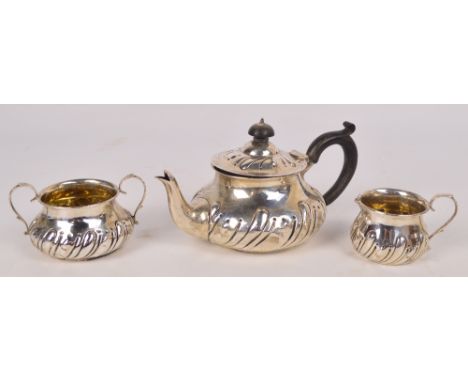An Edwardian hallmarked silver three piece bachelors tea service of globular form with part gadrooned body, Charles Edwards, 