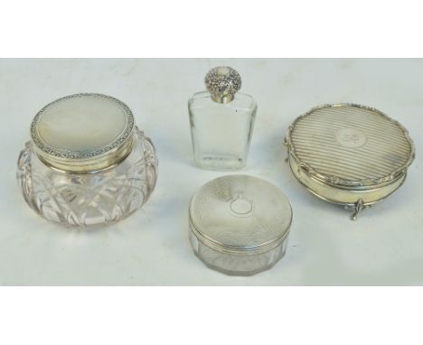 A George V hallmarked silver circular trinket box raised on three feet, with hinged lid centred with initialled cartouche, Ad