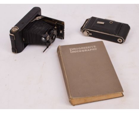 A Kodak Vollenda 620 folding camera with black bellows, a Kodak A120 folding camera and a book, "Progressive Photography" (3)