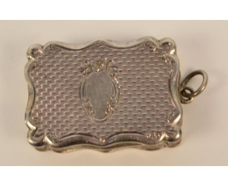 A Victorian hallmarked silver vinaigrette of shaped rectangular form with overall engine turned decoration, with scroll motif