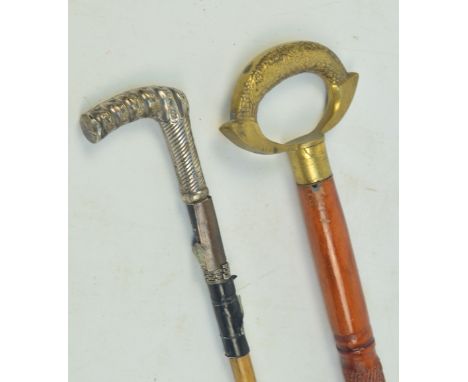 A bamboo stick with hallmarked silver spirally decorated handle and an incised example with brass ring handle (2).