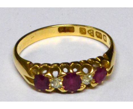 An 18ct yellow gold ruby and diamond ring, with three oval rubies alternating with two small diamonds, all set in a pierced g