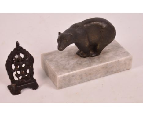 A bronzed model of a polar bear on a grey marble plinth, width of plinth 15cm, and a small bronzed ornament of an Eastern dei