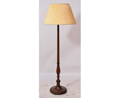 An early 20th century mahogany standard lamp with carved top above reeded column, above reeded lobed section to spreading cir