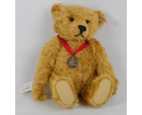 A boxed Steiff James teddy bear, no.654725, with numbered white and red tag to ear and sterling silver button, with golden bl