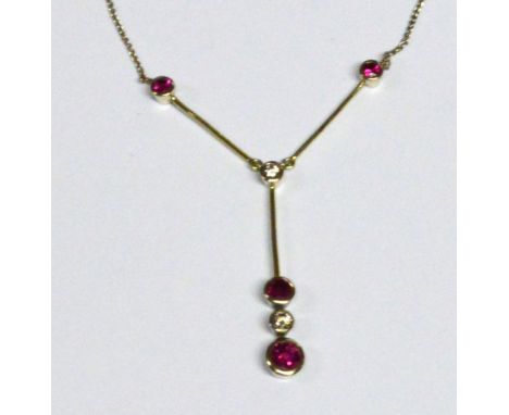 An 18ct white gold ruby and diamond pendant, the largest ruby set below a diamond and another ruby, all collet set with highe