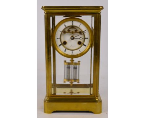 A French brass and bevelled glass cased eight day mantel clock, the circular skeleton enamel dial set with Roman numerals and