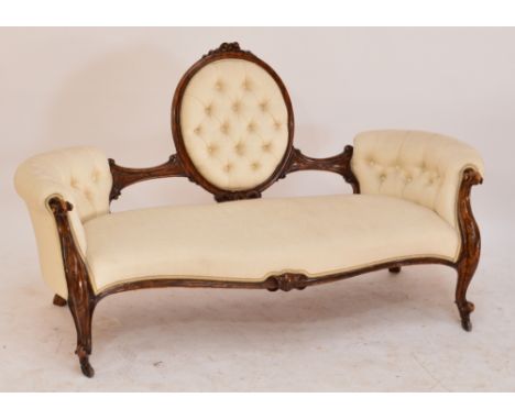 A Victorian simulated walnut cameo back salon settee with button upholstered padded back and arms, serpentine front rail, and