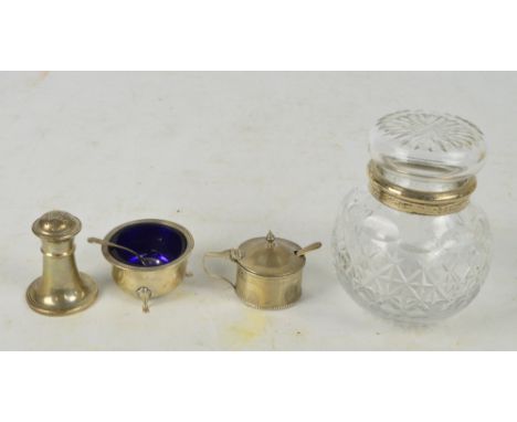 A George V hallmarked silver circular open salt on three outswept legs with blue liner and a matching pepper of tapering form