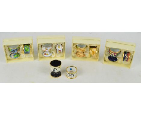 Five boxed Moorcroft enamel egg cup and napkin ring sets; Penguins, a trial piece signed and dated 2000 to base, Leaf and Ber