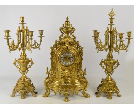 A large and ornate gilt metal clock garniture, the ornate pierced case with circular dial set with enamel hour points with Ro