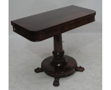 An early Victorian rosewood card table, the rounded rectangular hinged top revealing a baize interior above turned and carved