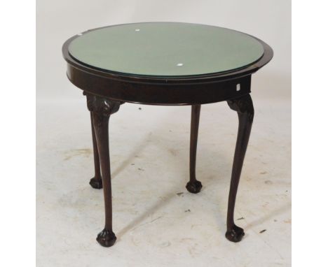 An early 20th century mahogany demi-lune foldover card table raised on cabriole legs and ball and claw feet.