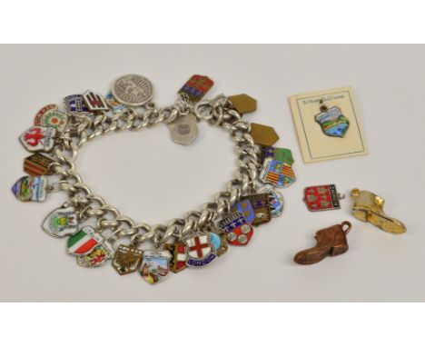 A silver charm bracelet suspending a number of predominantly enamelled shield shaped charms, approx 1.76ozt. CONDITION REPORT