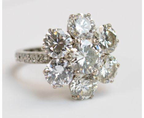 A good white metal floral diamond set ring, the central round brilliant cut stone weighing approximately 2cts within a border