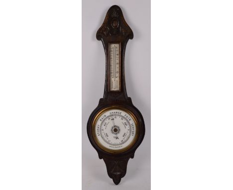 GAMAGE LONDON; a 1920s carved oak banjo aneroid barometer/thermometer, height 71cm.