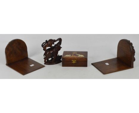 A pair of hardwood book ends decorated with carved opposing dragons, a carved hardwood figure of an elephant and two lions, a