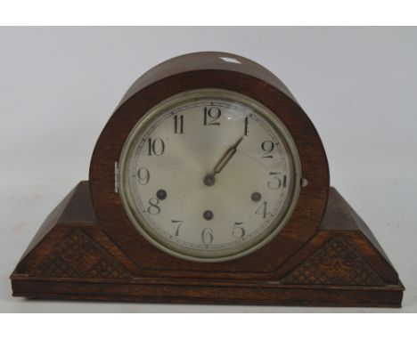 A 1950s oak mantel clock with silver dial set with Arabic numerals.