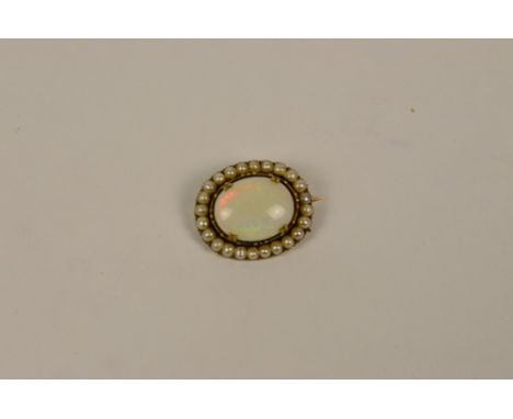 A yellow metal mounted oval brooch set with large opal within a pearl boarder, 2.5 x 2cm, approx 7g (af). CONDITION REPORT: T