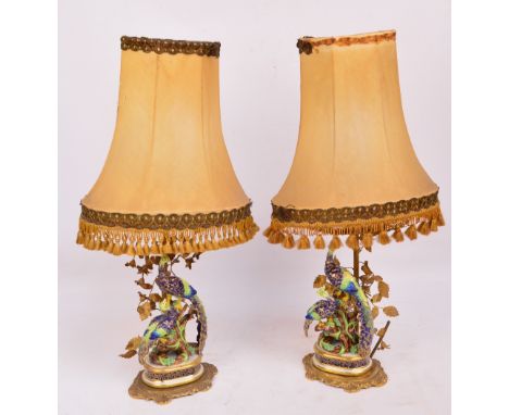 A pair of late 19th/early 20th century Samson porcelain models of peacock and peahen, both on gilt heightened oval plinths an