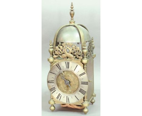 BRASS LANTERN CLOCK, the 6" silvered dial with single pierced hand and foliate carved centre on a two train movement striking