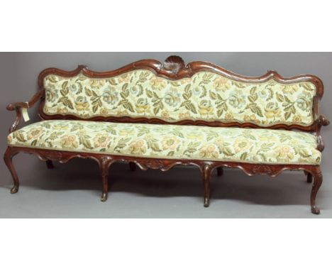 ITALIAN WALNUT SOFA, probably latter half of the 18th Century, the scrolling top rail with a central shell, padded back and s