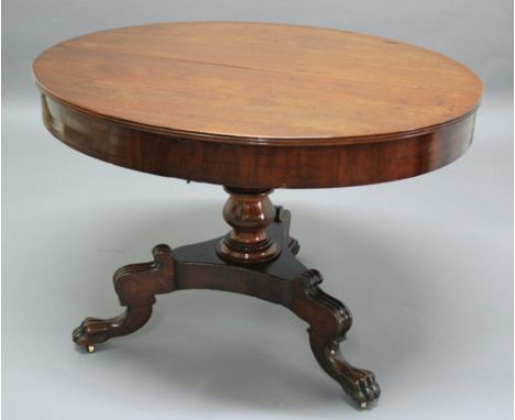 REGENCY MAHOGANY EXTENDING DINING TABLE, early 19th century, the oval top with plain frieze on a baluster column and tripod b