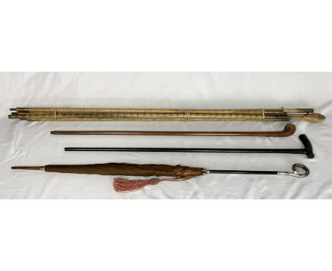 A vintage measuring pole named to A.B.C Rules & Measures and dated 1948 along with two walking sticks and a vintage umbrella 