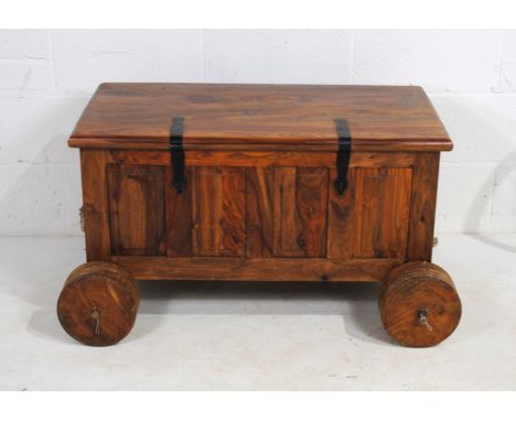 A Mexican pine trunk, on wheels, with rope handles