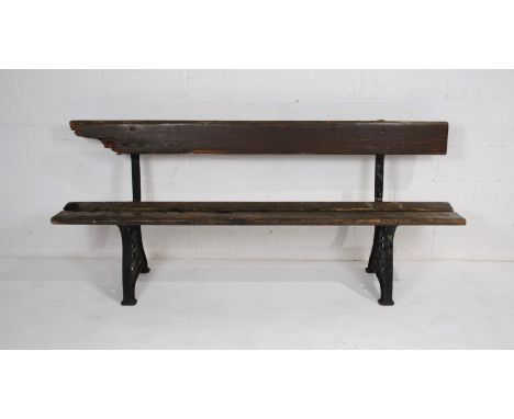 A weathered cast iron garden bench, with wooden slatted seat and back, possibly railway - length 195cm