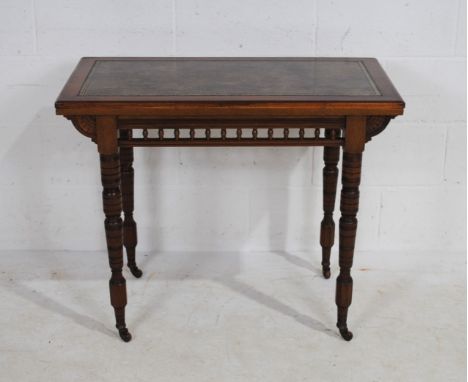 An Edwardian mahogany fold-over card table with leather inset top, on turned legs terminating ceramic castors, 91 cm wide, 48