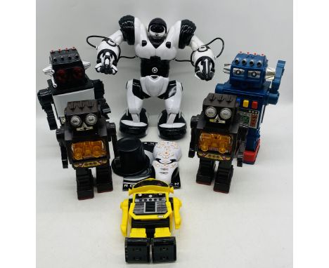 A Wow Wee Robosapien remote controlled robot with remote and manual, along with four battery operated toy robots and radio