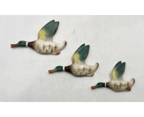 A set of three graduated ceramic flying ducks 