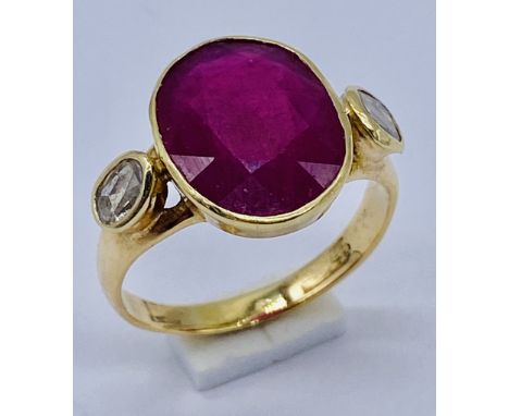 An 18ct gold (tested) ruby and diamond ring. The central ruby measuring approx. 13mm x 9.5mm with rose cut diamonds to the sh