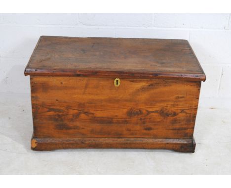 An antique elm tool chest, with brass drop carrying handles, ring marks to the top, damage to one corner, 84 cm wide, 47 cm d