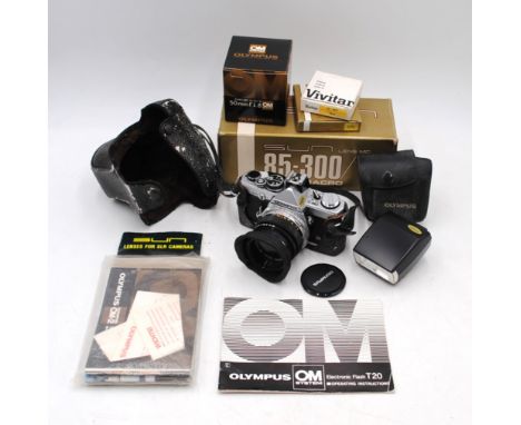 A vintage Olympus OM-2N camera, with 50mm lens, flash and boxes with paperwork etc.