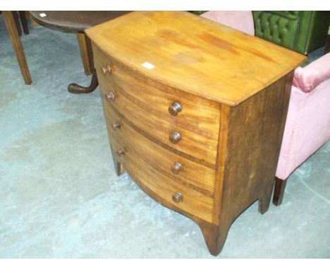 A 19th century mahogany bow front commode chest with a hinged top and four faux drawers with turned handles.